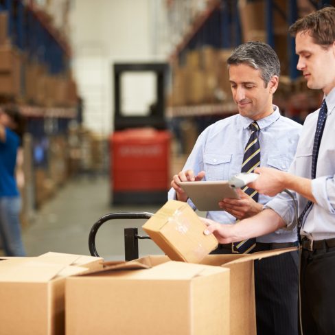 Businessmen Checking Boxes With Digital Tablet And Scanner